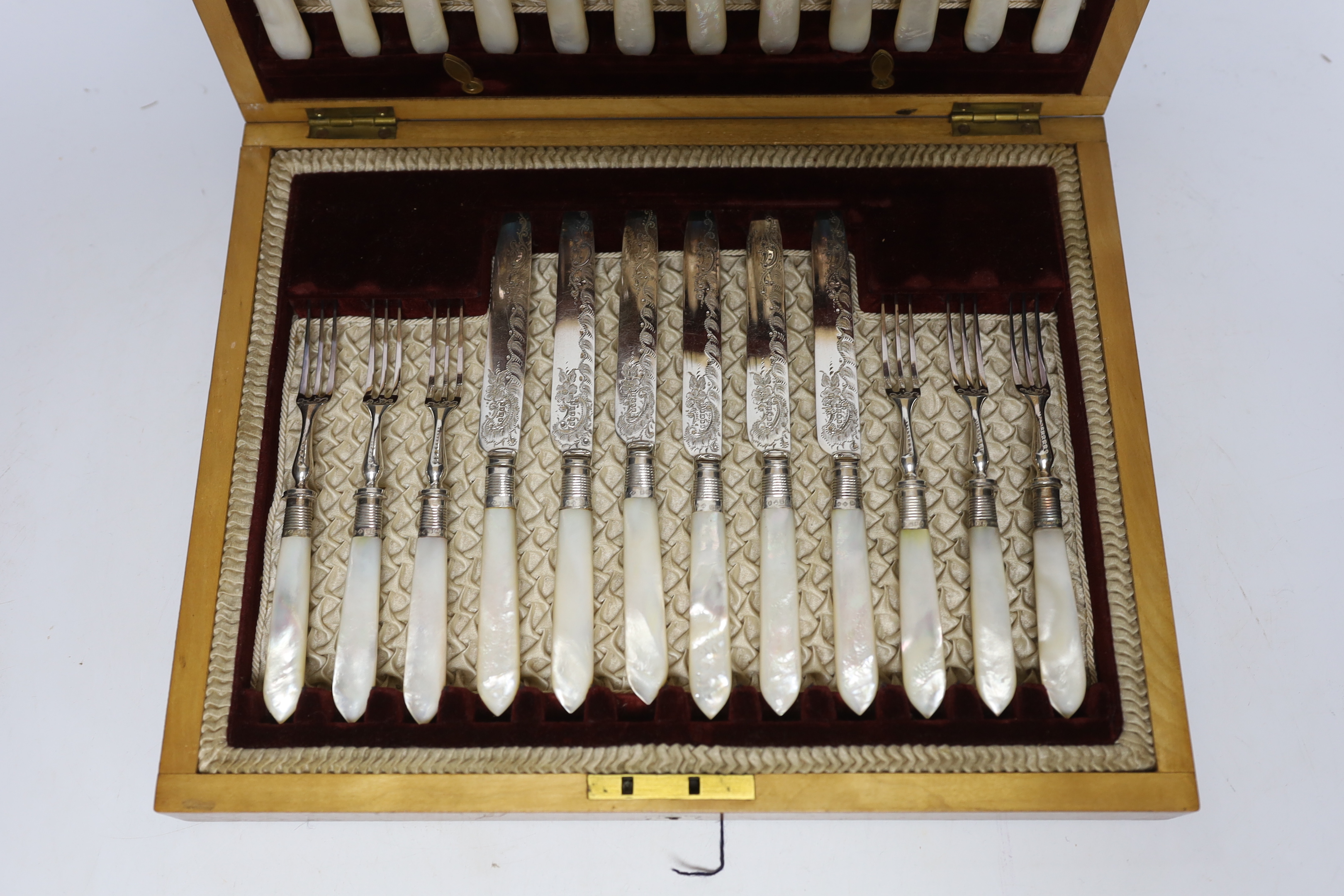 An Edwardian cased set of mother of pearl handled plated dessert knives and forks with silver collars, Sheffield 1901